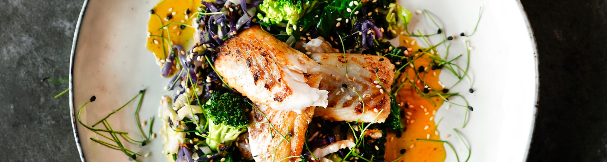 Kabeljau auf Spinat und Kohlgemüse auf Teller