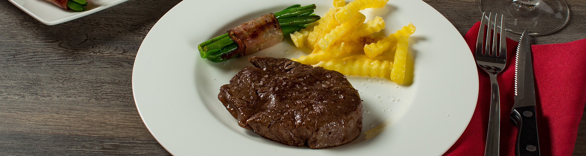Fleisch mit Fisolen und Pommes Frites auf Teller