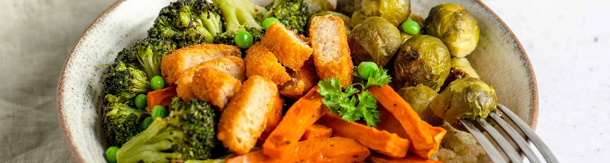 Bowl mit Ofengemüse, Green Cuisine Nuggets und Tahini-Erbsen-Sauce
