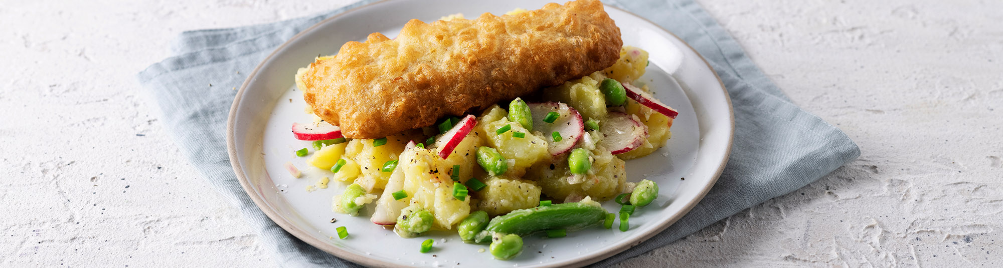 Backfisch mit Kartoffelsalat mit Zuckererbsenschoten, Sojabohnen und Radieschen