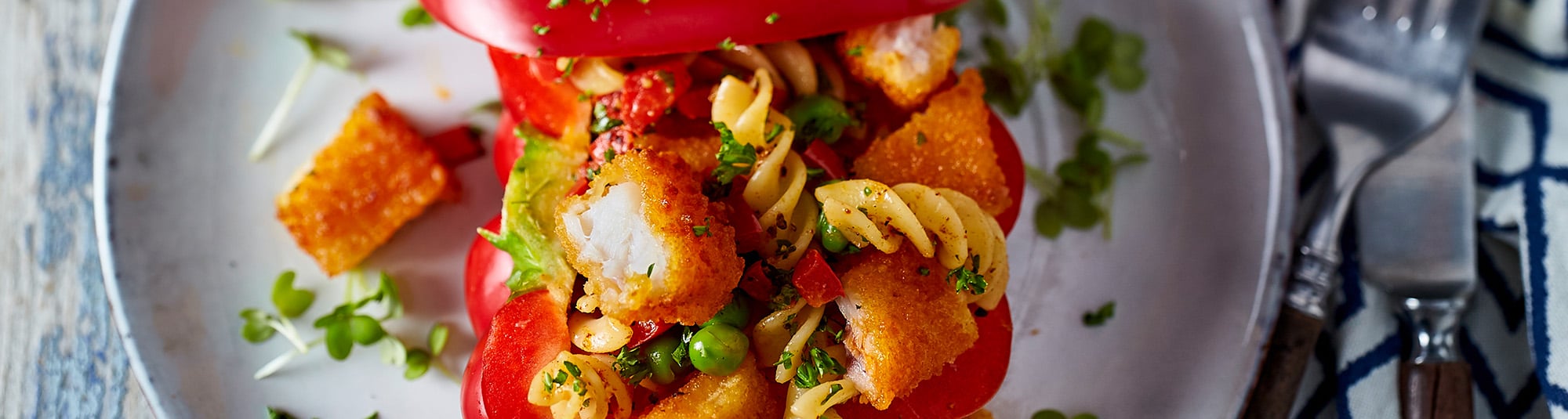 Paprika mit Fischstäbchen und Pasta gefüllt