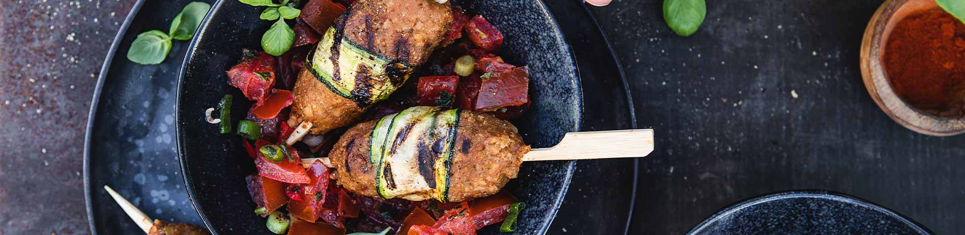GRILLSPIESSE AUS VEGANEM FASCHIERTEN IN ZUCCHINIMANTEL MIT TOMATEN-BASILIKUM-SALSA